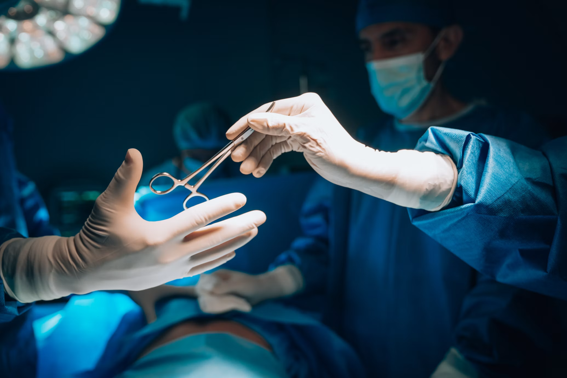 Surgical team passing an instrument in an operating room